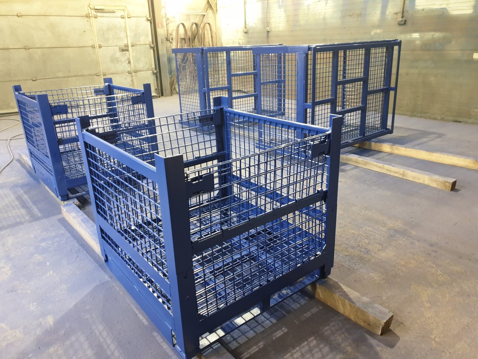 Blue cage pallets and gitterboxes used for repeat industrial handling and storage